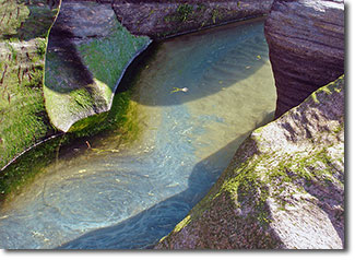 Sea water carving a channel through rock.